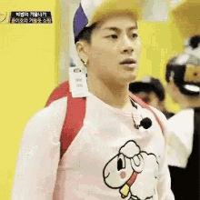 a man wearing a pink shirt and a purple hat