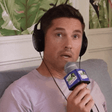 a man is wearing headphones and holding a microphone with a sticker on it that says ' netflix '