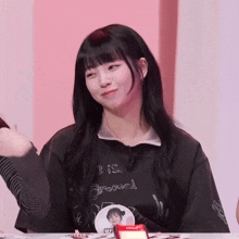 a girl wearing a black shirt that says ' e is around ' on it