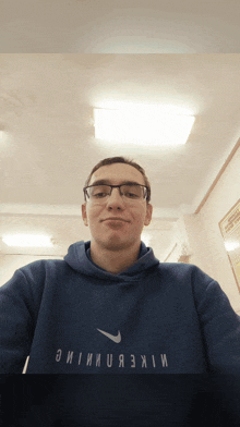 a man wearing glasses and a blue nike shirt