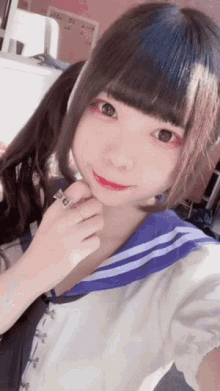 a girl with pigtails is taking a selfie with her hand on her chin