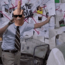 a man wearing sunglasses and a mask giving the middle finger in front of a bulletin board with the word pepe on it