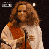 a man in a jesus costume stands in front of a microphone with the words son of a grifch above him