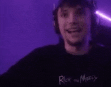 a man wearing headphones is singing into a microphone in a purple room .