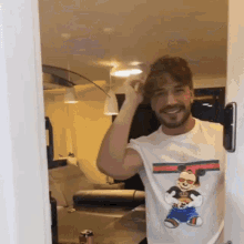 a man wearing a mickey mouse t-shirt is standing in a doorway