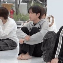 a group of young men are sitting on the floor .