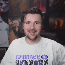 a man with a beard wears a shirt that says embrace the unknown
