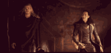 a man in a black cape is standing next to another man