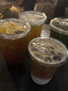four cups of iced drinks with the word nuk on them