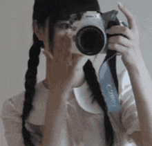 a woman taking a picture with a camera that says canon