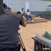 a man in a black shirt is taking a picture of two people sitting on steps