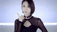a woman wearing a choker and a black top is pointing upwards