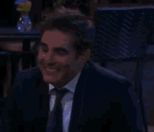 a man in a suit and tie smiles and says you 're working way too hard