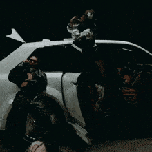 a man smoking a cigarette next to another man in a car