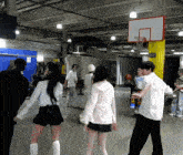 a group of people are playing basketball in a room with a basketball hoop and a sign that says exit