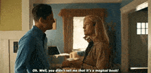 a man and a woman are standing next to each other in a living room talking to each other .