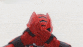 a person wearing a red helmet and gloves is making a funny face .