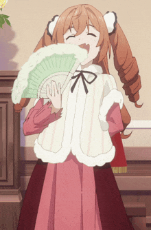 a girl in a pink dress is holding a fan in front of her face