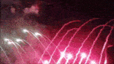 a bunch of pink fireworks are going off in the sky