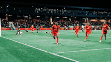 a group of soccer players on a field with one wearing a red jersey that says ' allianz ' on it