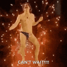 a shirtless man in a bathing suit is dancing in front of a fireworks display .