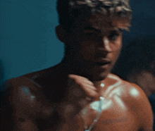 a man without a shirt is looking at himself in a mirror