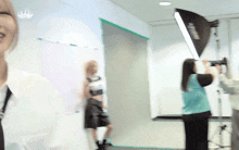 a woman in a green vest is standing in front of a light that says ' fujinon ' on it