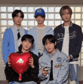 a group of young men are posing for a picture and one of them is wearing a blue hat that says thank you for being daddy