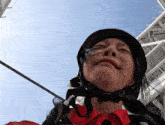 a woman wearing a helmet and a red shirt is making a face