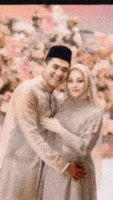 a man and a woman are posing for a picture and the man is wearing a black hat