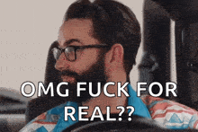a man with a beard and glasses is driving a car and saying omg fuck for real ?