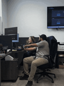 two people sitting in front of a computer monitor that says sceptre