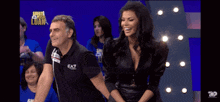a man and a woman are standing next to each other on a stage and the man is wearing a shirt that says eaz