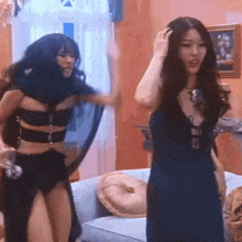 two women in black dresses are dancing in a room