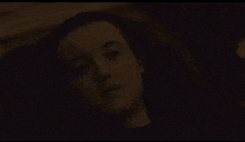 a close up of a woman 's face in a dark room
