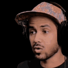 a man wearing a hat and headphones looks surprised