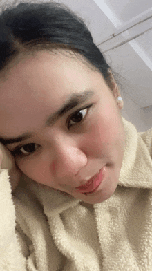 a close up of a woman 's face with a white sweater on