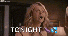 a man with long hair is holding a purple eggplant in his hand and says tonight .