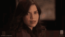 a close up of a woman 's face with a serious expression .