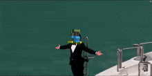 a man in a tuxedo is standing on the side of a yacht in the ocean .