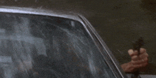 a man looking out of a car window with a reflection of a fire