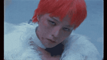 a woman with red hair and a white fur coat looks at the camera