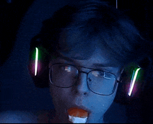a close up of a person wearing headphones and glasses eating sushi .