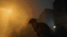 a blurry picture of a man standing in front of a fire at night .
