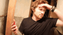 a man in a black shirt is holding a red object in his right hand