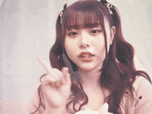 a girl with pigtails is pointing at something