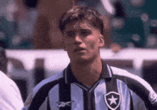 a man wearing a black and white striped shirt with a star on the front