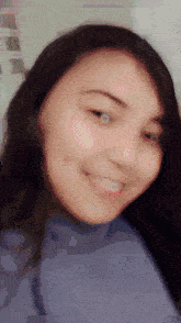 a close up of a woman 's face with a blue shirt on
