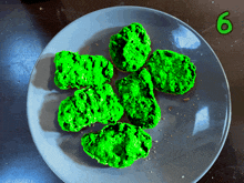 a plate of green cupcakes with the number 6 on the bottom