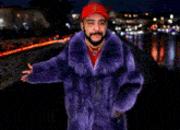 a man in a purple fur coat and a red hat with a fleur de lis on it